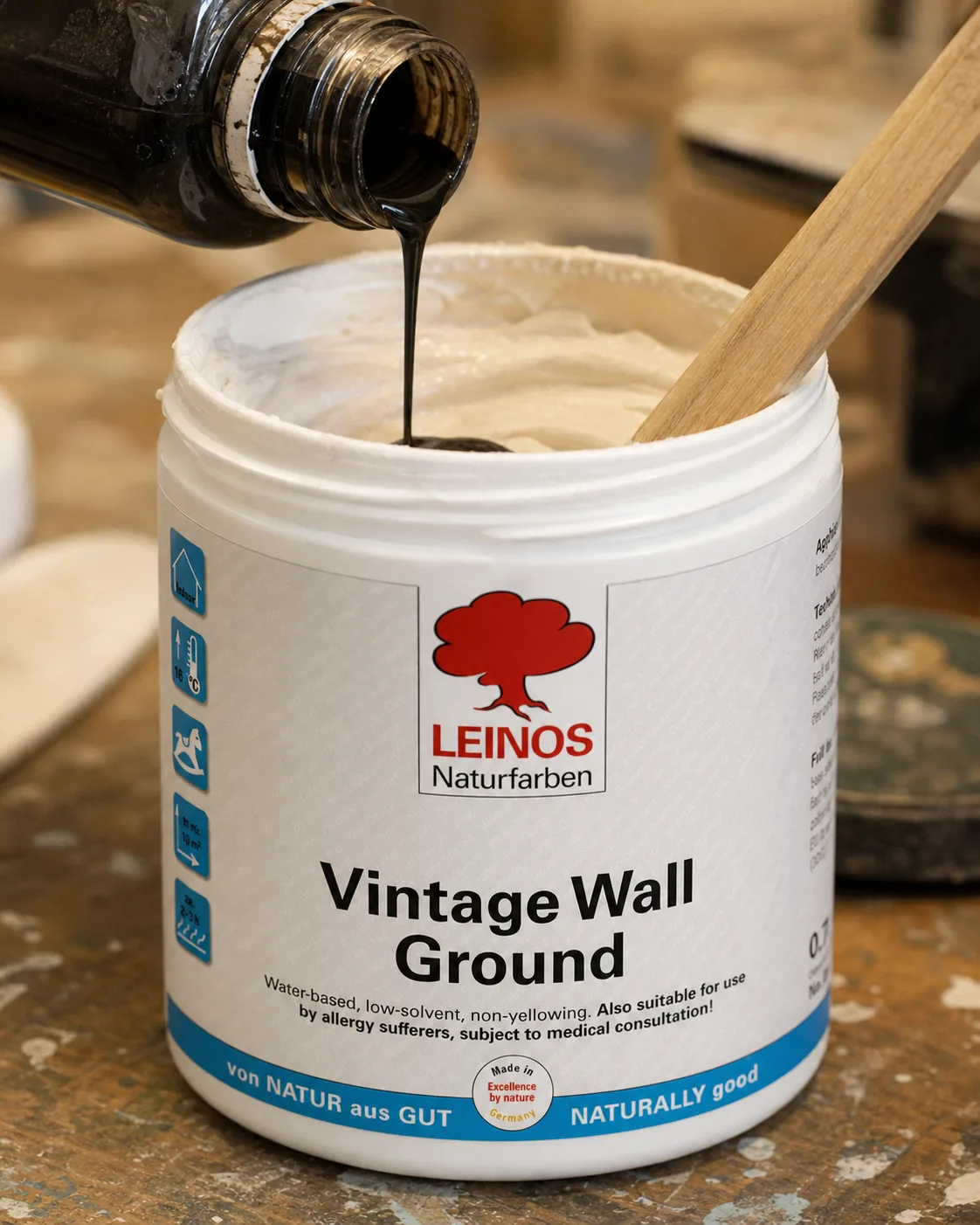 Pouring LEINOS 668 Pigment Concentrate into an open branded LEINOS 631 Vintage Wall Ground can and stirring the tinted compound