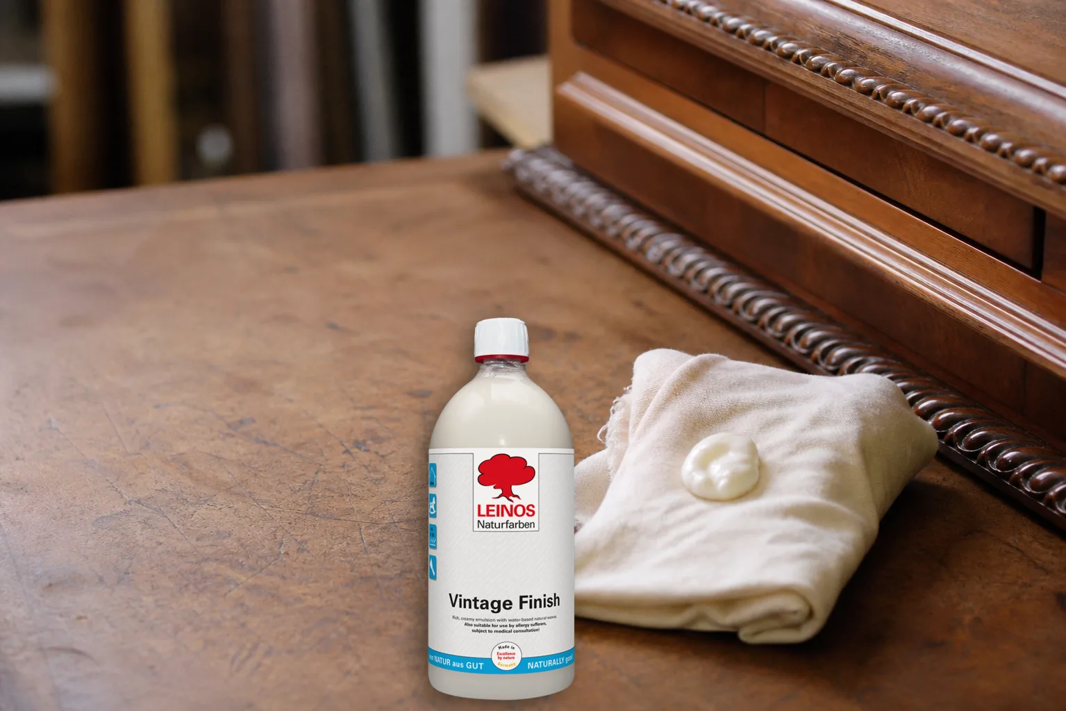 Dispensing creamy white wax emulsion from the branded LEINOS 635 Vintage Finish 1 litre bottle onto a folded cotton cloth
