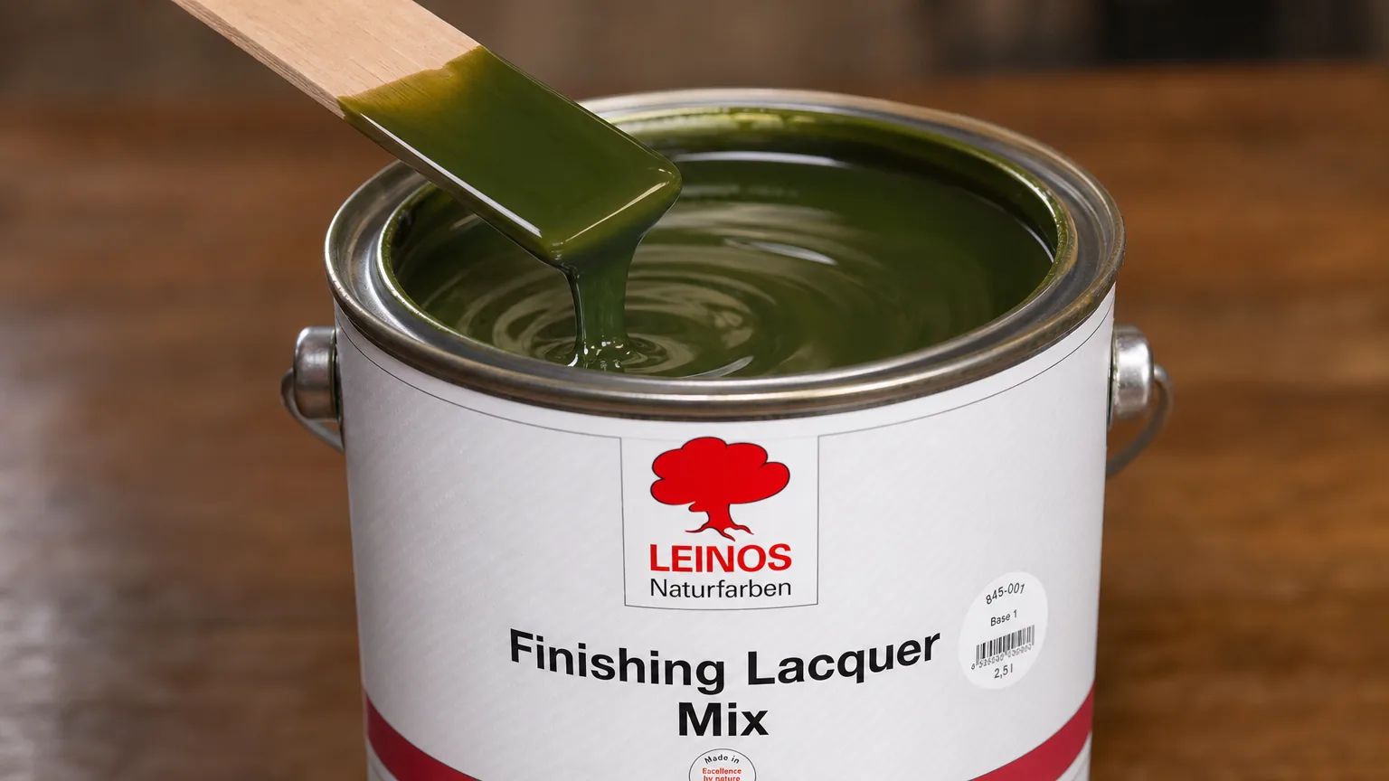 Stir stick folding a fluid fir-green silk-gloss lacquer inside an open branded LEINOS 845 tin