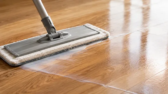 A flat mop laying a thin milky film of floor care across a clean oiled oak floor