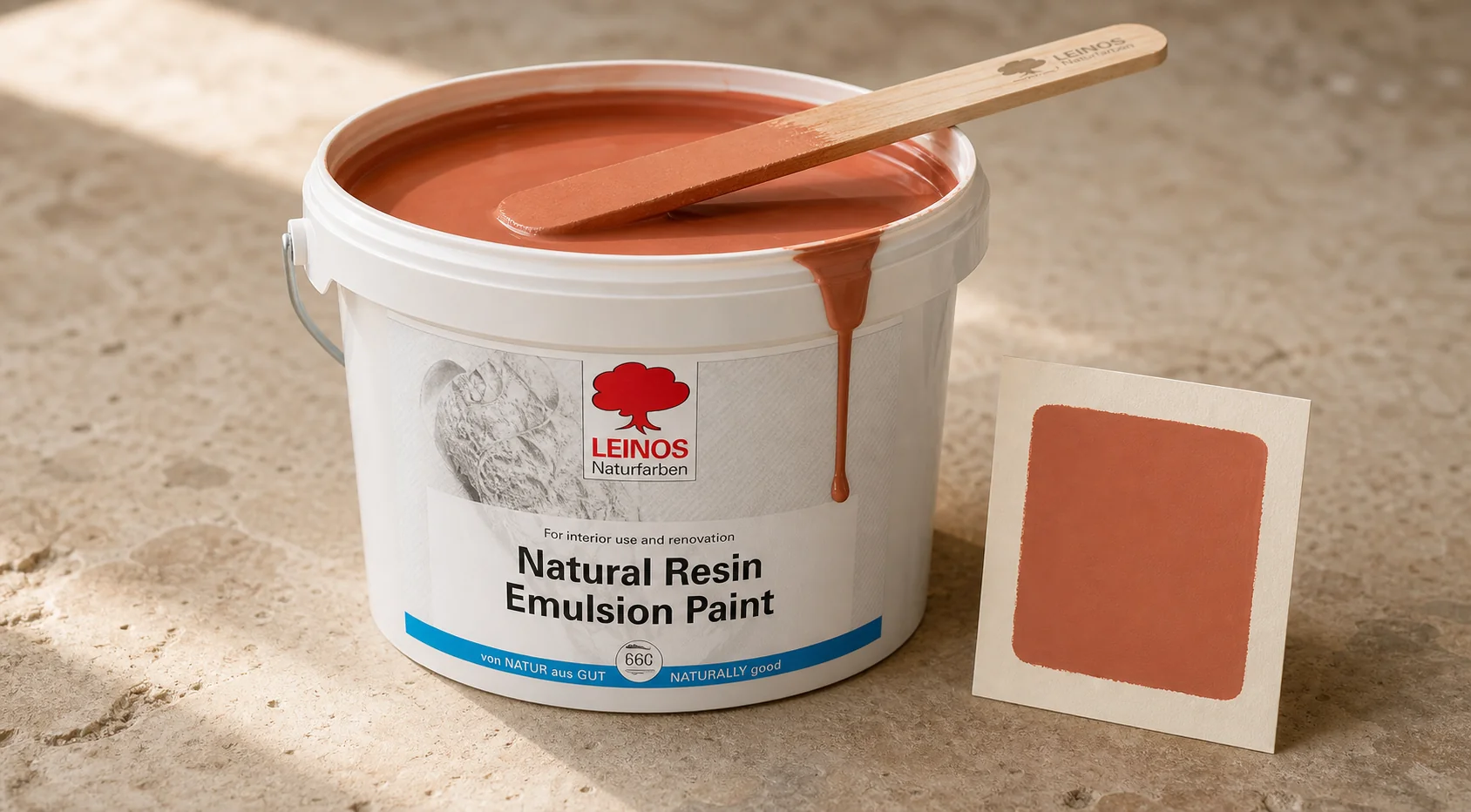 Final tinted batch of host paint stirred to uniform shade, sample swatch card alongside on kota stone