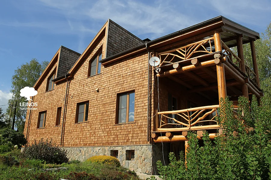 Cedar shingle detail after monsoon — water beading visible on shingle faces, no chalking or peeling at course transitions.