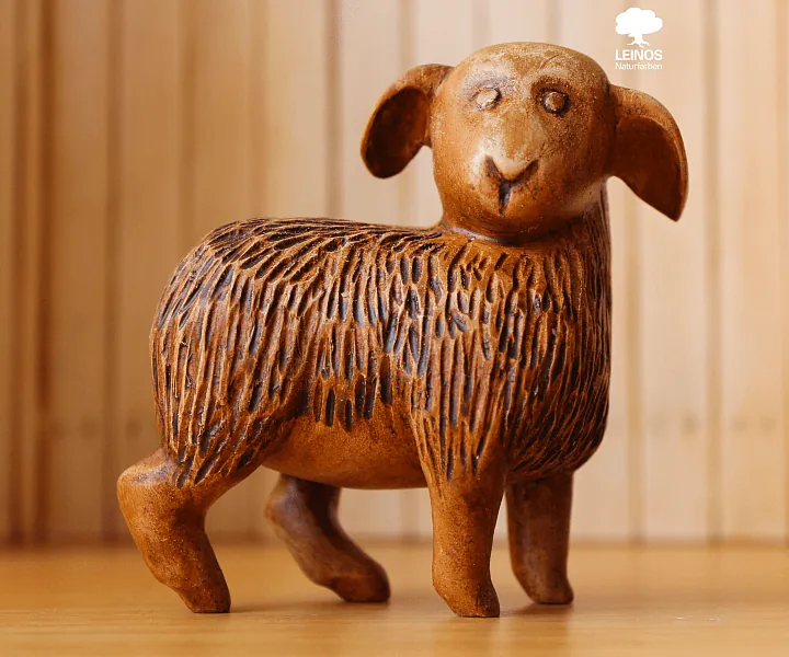 Animal figures (sheep or ox) — smooth tactile surface, splinter-free for a child's grip.