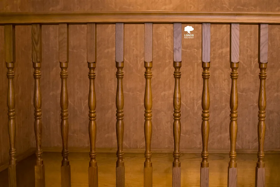 Stair tread and riser junction — uniform golden-amber tone with no pooling at the spindle base.