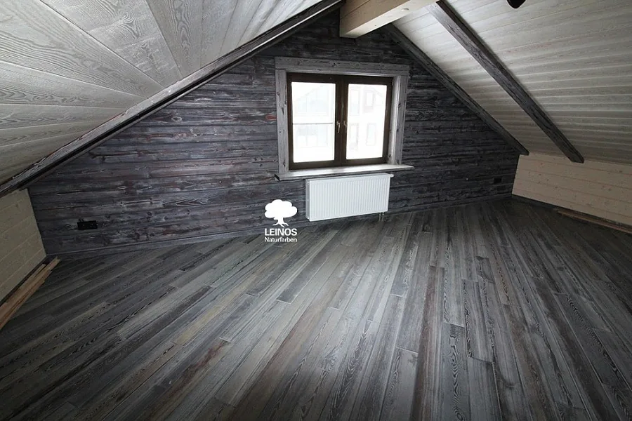Wide view showing the foot-traffic floor and wall planks under indirect daylight — single grey register across both planes.