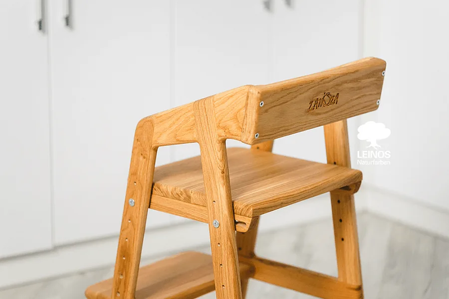 Detail of the adjustable seat mechanism showing warm honey colour with visible grain.