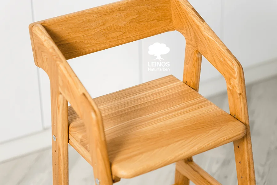 Footrest slot detail — smooth satin oil finish across the adjustment positions.