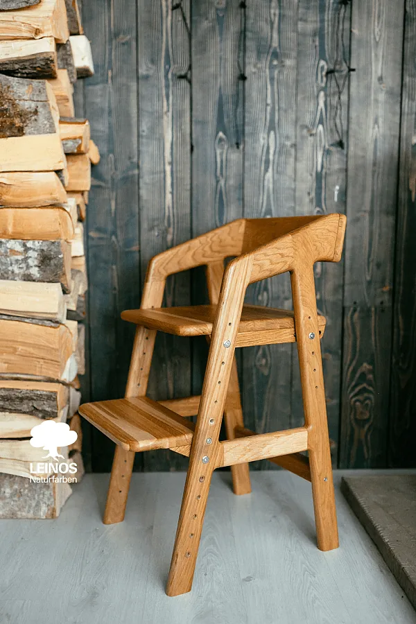 Full chair front view at growing position — warm honey wood tone with soft satin sheen.