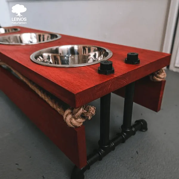 Detail of a bowl-hole rim — wear point holding the red stain without scuffing through after daily use.