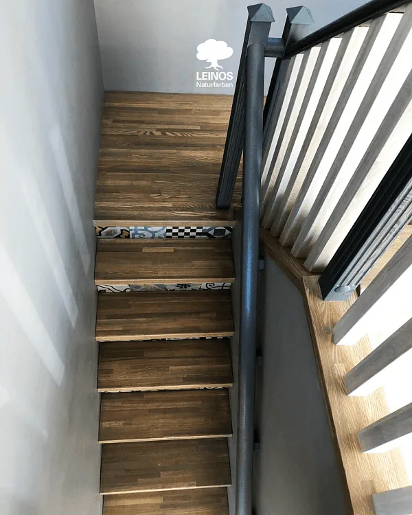 Stair run from below — alternating oak treads and patterned risers creating visual rhythm.