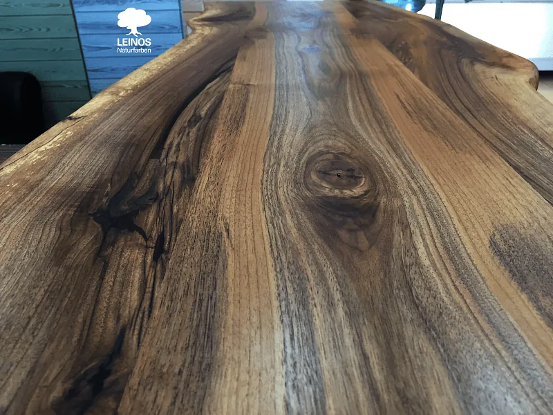 Close-up of the walnut grain — near-black heartwood transitioning to rich mid-brown sapwood under the oil finish.