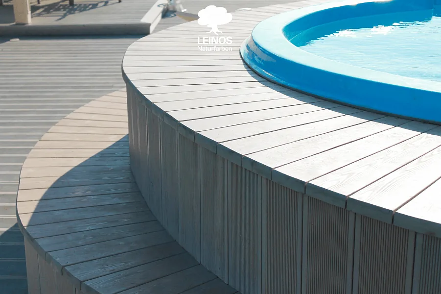Top view of the curved deck — radial boards meeting at the pool rim, uniform grey across the radii.