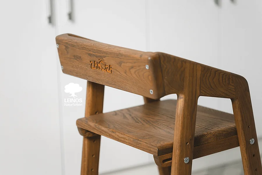 Footrest close-up showing food-safe satin oil finish over the pigmented oak.