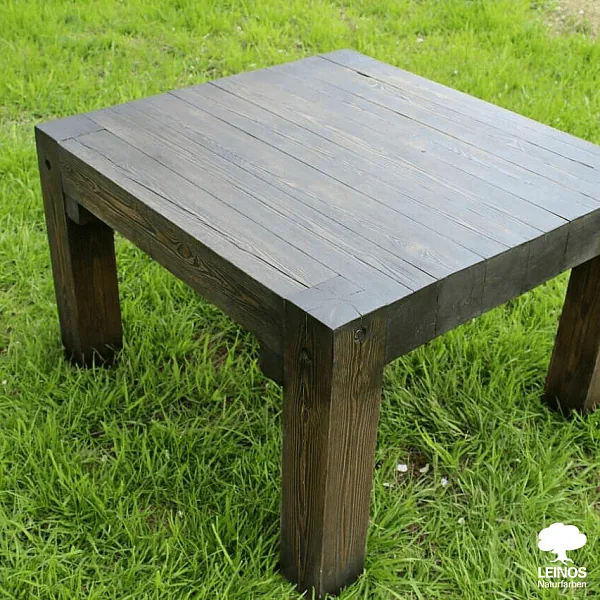 Close-up of the table top surface — rough-sawn texture preserved, dark oil penetration without filming.