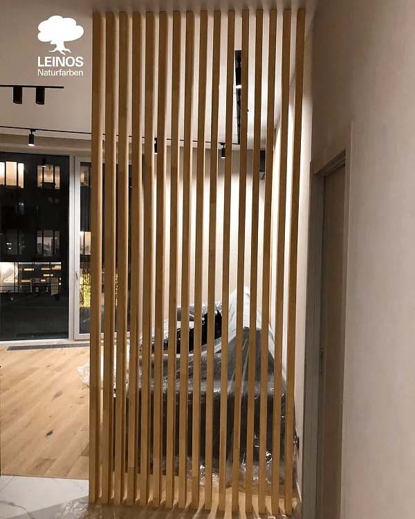 Slat-to-plaster junction — clean tonal break between wood feature wall and neutral plaster surround.
