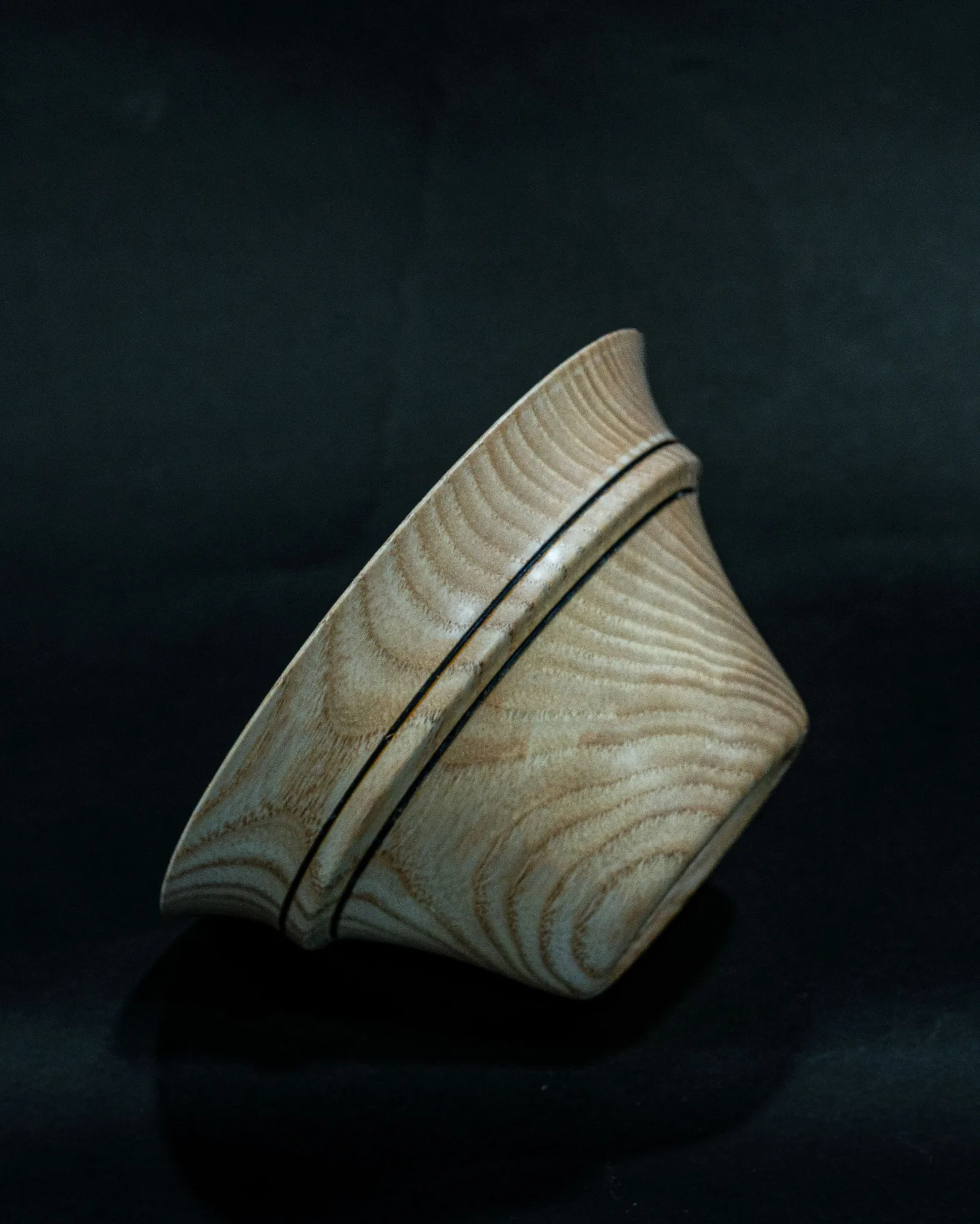 A turned white-ash bowl by Kathkani Studio tipped to show its flared form and wire-burned bead rings, finished in LEINOS Interior Hardwax Oil 290.