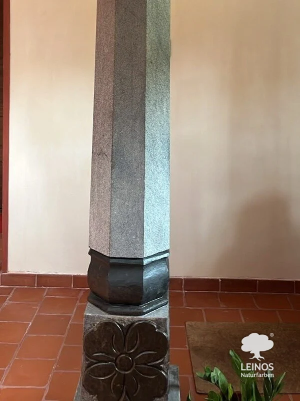 A stone column on a carved base beside terracotta flooring in the Bengaluru home, impregnated with LEINOS Stone and Concrete Oil 254 — a colourless, water-repellent treatment that does not significantly darken the stone.